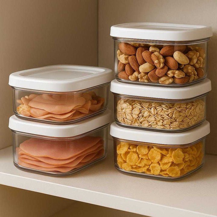 Opbevaring container i plastik, klar og hvid, holder maden frisk, 'stackable', gennemsigtig, 1 stk: A different realistic pantry setting where the plastic container is securely positioned on a shelf, stacked with other similar containers, filled with various dry foods like nuts and cereal.