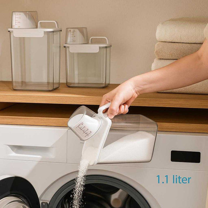 Opbevaring til Vaskepulver - Høj Kvalitet Beholdere med Tætsluttende Låg i 1000 ML, 1800 ML, 2300 ML: A realistic laundry room setting where the product is properly grounded on a wooden shelf, being used by a person who is pouring washing powder from the container into a washing machine, with natural lighting casting realistic shadows and showing clear contact points where the container touches the shelf and the person's hand.