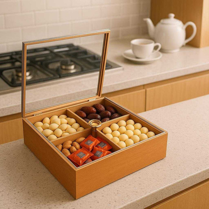 Opbevaringsboks i Træ med Låg og 4-delt Opdeling - Elegant og Funktionel Design. The functional wooden storage box sits on a modern kitchen counter, with its lid open to reveal a delightful assortment of snacks, ready to serve for an afternoon tea gathering.
