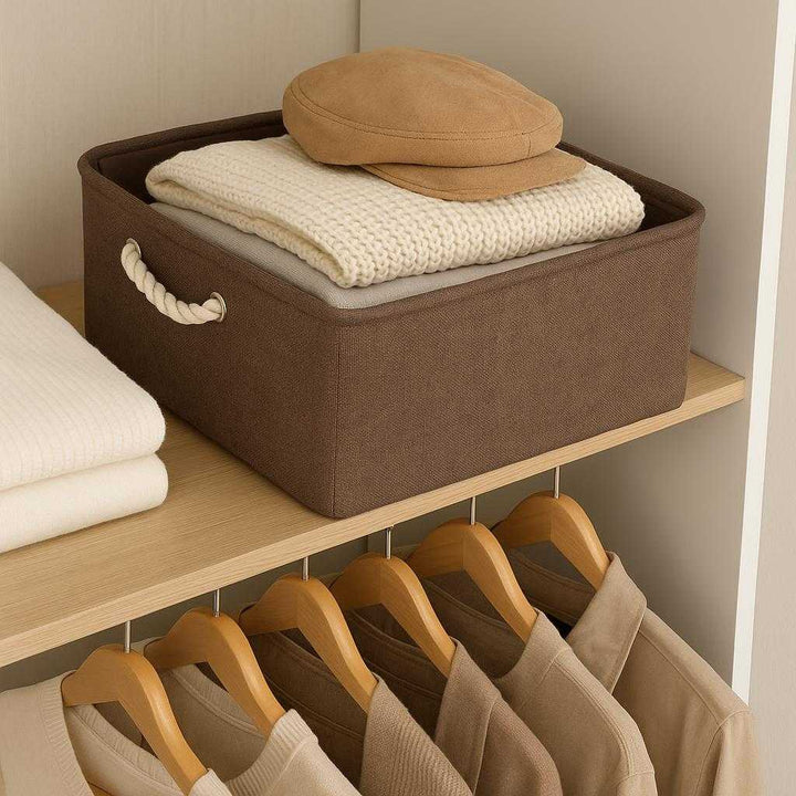 Opbevaringspose i kraftigt stof med snøre – Foldbar og slidstærk løsning til hjem og rejse i brun, beige og grå: A different realistic bedroom setting where the storage bag is securely positioned on a closet shelf, being used as a storage solution for neatly folded clothes and accessories, with proper physics, shadows, and realistic integration into the environment, enhancing the tidy and organized feel of the wardrobe space.