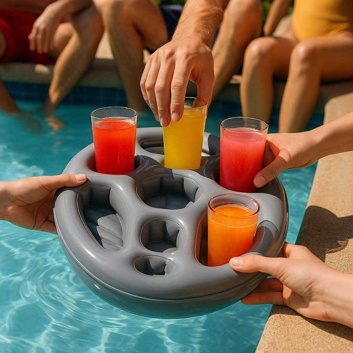Oppustelig Drikkeholder med Flere Rum - Perfekt til Pool og Fest i Grå Plast: A realistic poolside setting where the inflatable drink holder is properly grounded in a clear blue pool, being actively used by a few hands placing colorful drinks into the compartments.