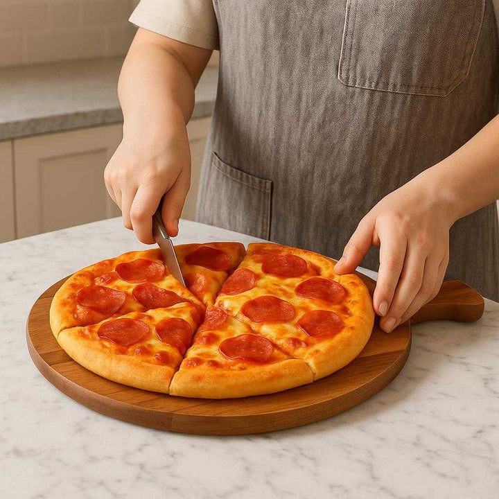 Pizza Bræt i Massivt Træ - Let at Bære, Æstetisk, Holdbart - 38.1 cm: A realistic kitchen setting where the pizza bræt i massivt træ is properly grounded on a marble countertop, being actively used to serve a freshly baked pizza with melted cheese and toppings.