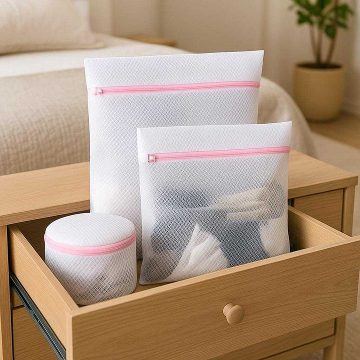 Polyester vasketøjsnet poser - 4 stk. net stofmateriale og plastik lynlås - hvid og lyserød: A different realistic bedroom setting where the polyester laundry bags are securely positioned in an open drawer of a dresser, being used to organize socks and small garments.