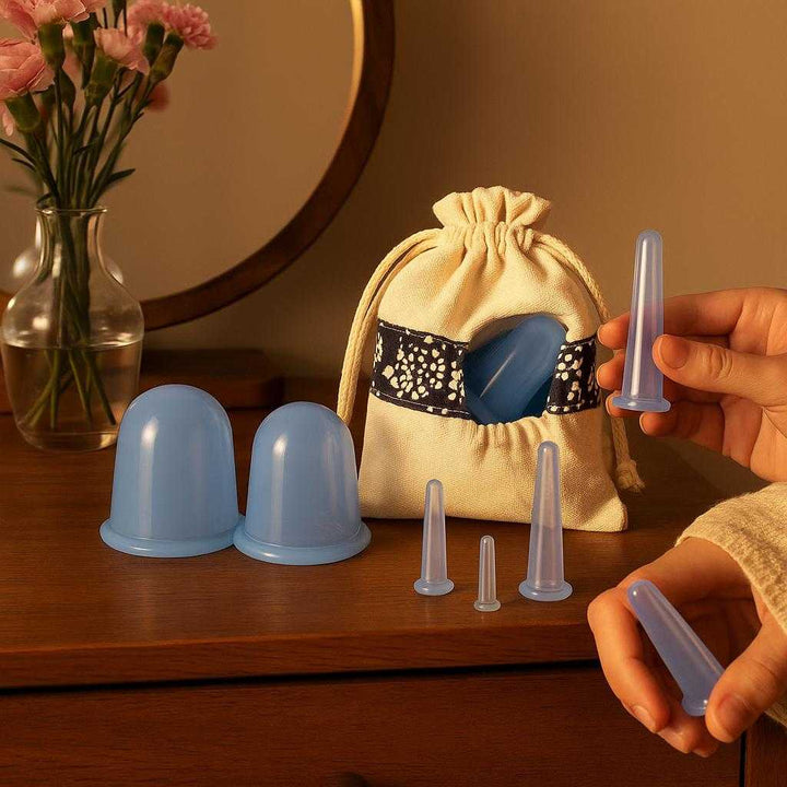 Professionelt Cuppingsæt til Ansigt - 6 Silikonekopper i Lyseblå med Opbevaringspose: A different realistic bedroom vanity setting where the product is securely positioned on a wooden dresser, naturally placed beside a small mirror and a vase of fresh flowers.