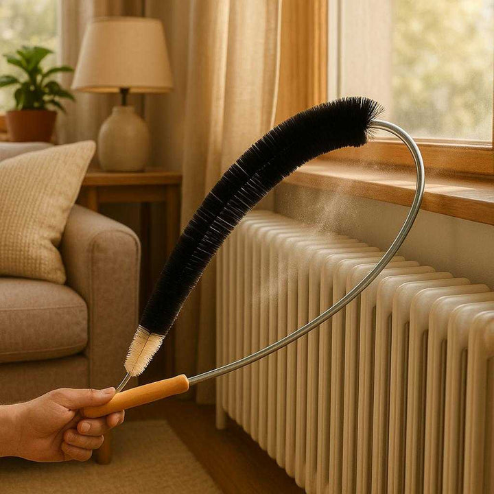 Radiatorbørste med Fleksibel Metalstang og Træhåndtag - Effektiv Rengøring af Radiatorer. In a cozy living room, the flexible radiator brush is expertly cleaning between the narrow fins of a white radiator, with dust visibly being lifted as sunlight streams through a nearby window.