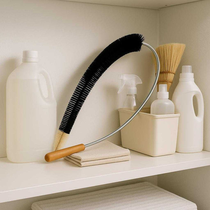 Radiatorbørste med Fleksibel Metalstang og Træhåndtag - Effektiv Rengøring af Radiatorer. The wooden-handled radiator brush rests on a tidy utility room shelf, alongside neatly organized cleaning supplies, evoking a sense of efficiency and cleanliness.