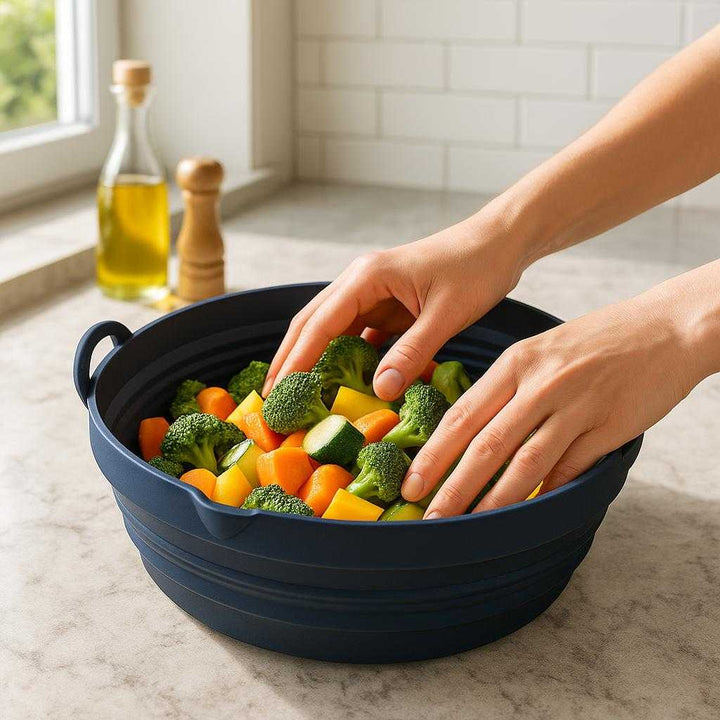 Sammenklappelig Airfryer Silikoneform Rund - Professionel Fleksibel Opbevaring til Sund Madlavning: A realistic modern kitchen setting where the collapsible airfryer silicone mold is properly grounded on a marble countertop, being actively used by hands to prepare healthy vegetables.