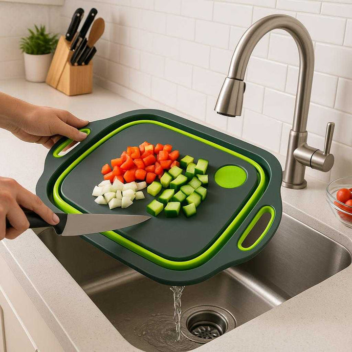 Sammenklappeligt skærebræt med afløb og håndtag – Multifunktionelt og Pladsbesparende Design i Moderne Grå og Lysegrøn. In a modern kitchen, the gray and light green collapsible cutting board is used to chop vegetables next to a sink, with water draining smoothly through the built-in hole into the basin below.