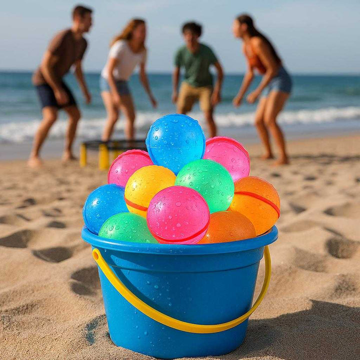 Selvlukkende Vandballoner med Hurtigfyldende Funktion - Farverig og Genanvendelig Sommerleg: A different realistic beach setting where the colorful water balloons are securely positioned in a sand bucket on a soft sandy surface.