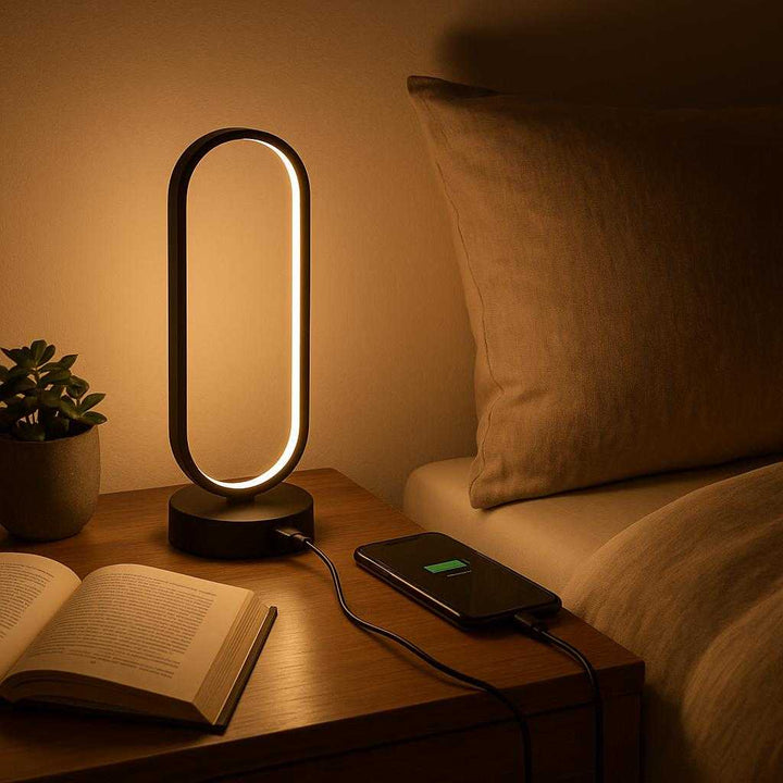 Sengelampe med USB og Touch-kontrol - Moderne Sort Bordlampe med LED: A cozy bedroom setting where the modern black LED bedside lamp is placed on a sleek wooden nightstand next to a plush, neatly made bed with neutral-toned linens.