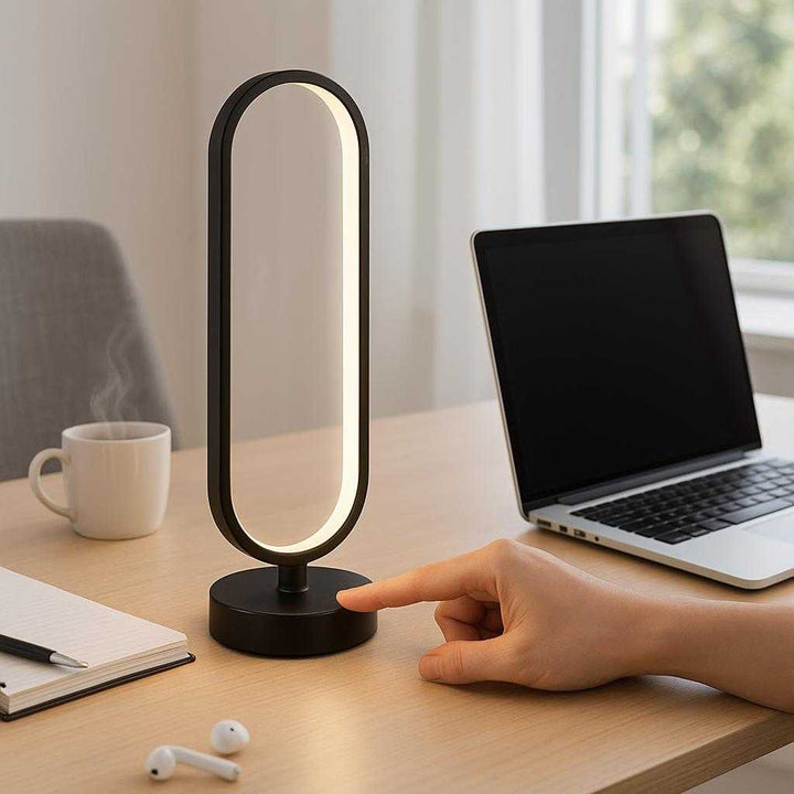 Sengelampe med USB og Touch-kontrol - Moderne Sort Bordlampe med LED: A contemporary home office environment where the stylish black LED table lamp is positioned on a clean, minimalist desk, adjacent to a sleek laptop.