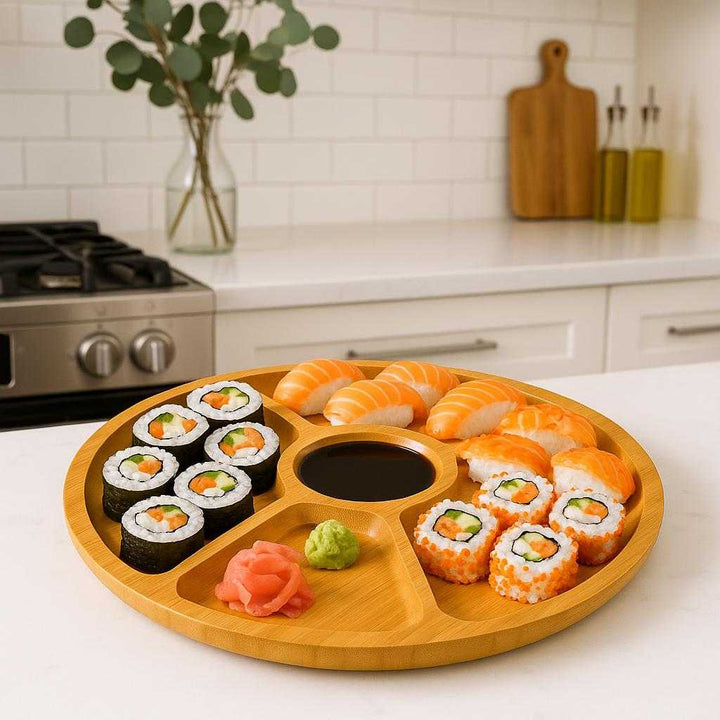 Serveringsfad i Bambus med 5 Rum – Rundt Design, Høj Kvalitet til Stilfuld Servering. In a modern kitchen, the bamboo serving platter displays a colorful assortment of sushi and sauces, ready for a family dinner celebration.