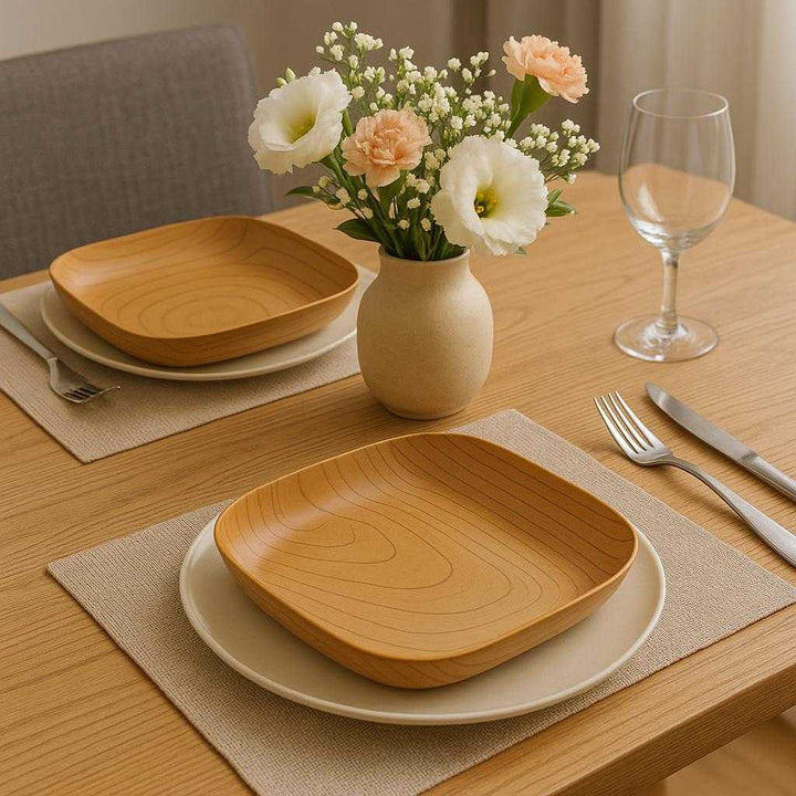 Serveringsfad i Trælook – Elegant og Alsidig Servering til Hjemmet med Naturlig Æstetik. A beautifully set dining table features the versatile wooden-look platter, elegantly placed alongside matching dinnerware and a vase of fresh flowers, evoking a sense of natural aesthetic in a modern dining room.