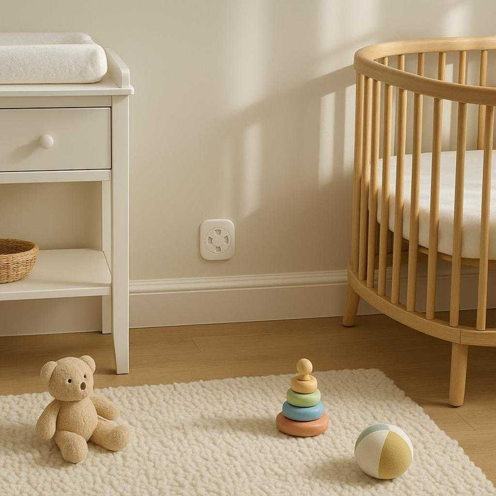 Sikkerhedsdæksler til stikkontakter - Moderne og effektiv børnesikring i hvid plast: A different realistic nursery setting with a crib and toys neatly arranged.