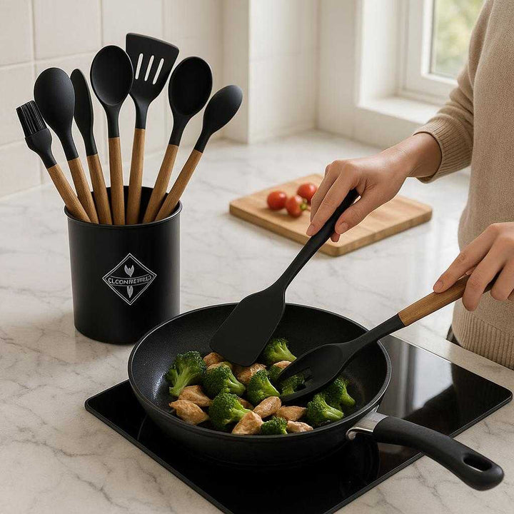 Silikone køkkenredskaber i sæt - Varmeresistente og skånsomme redskaber til alle gryder og pander i Sort, Grøn, Rød: A realistic modern kitchen setting where the silicone kitchen utensils are properly grounded on a sleek marble countertop, being actively used by a person preparing a meal.