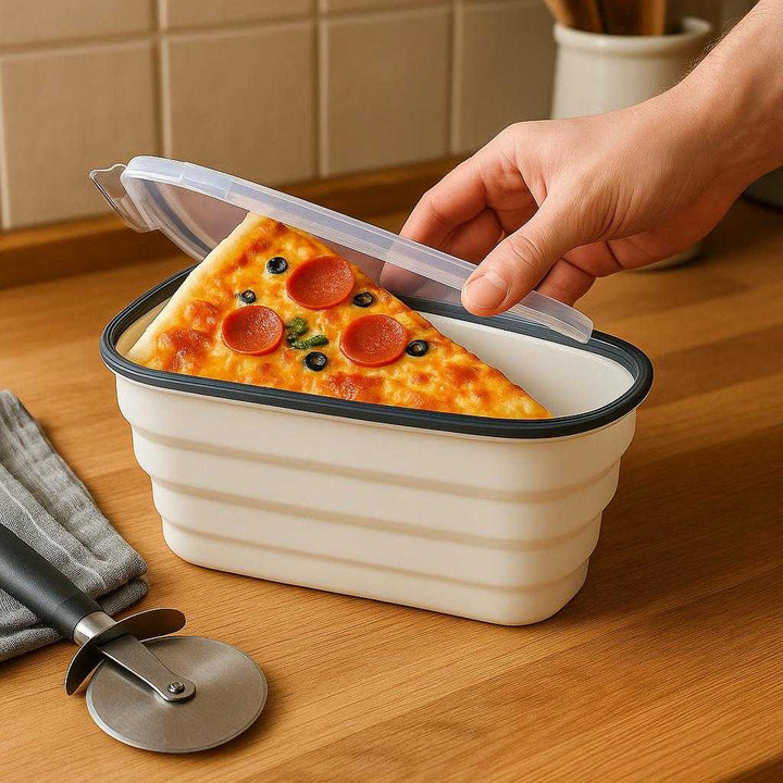 Silikone Pizza Opbevaringsbeholder - Hvid, Plastik, Silikone, Gennemsigtigt Låg, Pladsbesparende: A realistic kitchen setting where the Silikone Pizza Opbevaringsbeholder is properly grounded on a wooden kitchen counter, being actively used by a person's hand to place a fresh slice of pizza inside.