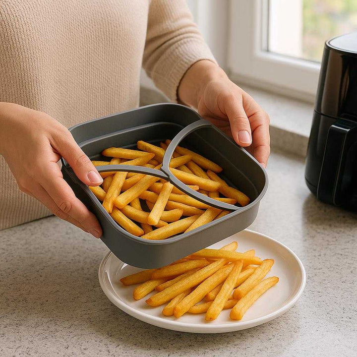 Silikoneform til Airfryer med Non-stick Riller og Håndtag - Høj Kvalitet Fleksibel Kvadratisk Design, 400g: A realistic kitchen setting where the silicone air fryer mold is properly grounded on a kitchen counter, being actively used by a person to transfer freshly cooked fries from the air fryer to a serving plate.