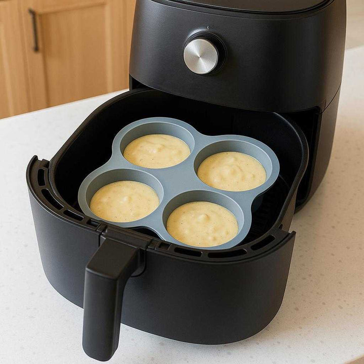 Silikoneform til Airfryer og Mikroovn - Høj Kvalitet, Foldbar, Grå, 80g: A different realistic kitchen setting where the silicone form is securely positioned inside an air fryer basket, loaded with small muffin batter ready to bake.