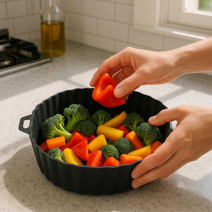 Silikoneform til Airfryer: Professionel Fleksibel Silikone med Høj Kvalitet for Sund Madlavning: A realistic modern kitchen setting where the silicone air fryer mold is properly grounded on a countertop, being actively filled with fresh vegetables by a person's hands, ready for air frying.