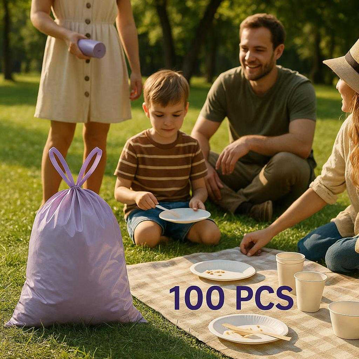Skralde poser - Lilla, Plastik, Stor Kapacitet, Holdbarhed, Let at binde, 1 Rulle Med 100 stk, Standard Kvalitet: A different realistic outdoor picnic setting where the product is securely positioned on a park grass surface, being used to collect picnic trash with family members around.