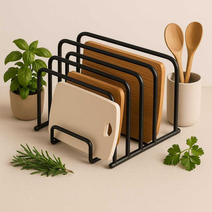 Skærebrætholder i Sort Metal – Professionel og Pladsbesparende Opbevaring med Høj Kvalitet. A minimalist kitchen setup showcases the black metal cutting board holder elegantly displaying cutting boards beside fresh herbs and culinary utensils, enhancing space efficiency.