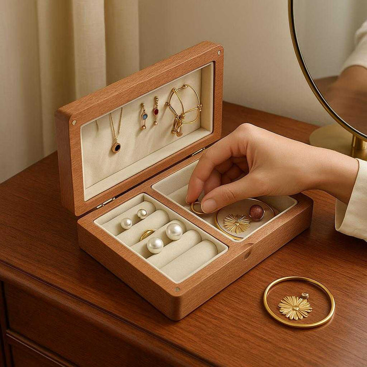 Smykkeskrin i træ - Klassisk design med optimal organisering, tilgængelig i lysebrun og mørkebrun: A realistic bedroom vanity setup where the wooden jewelry box is properly grounded on a polished wooden dresser, being actively used by an elegant hand picking a ring from inside the box.