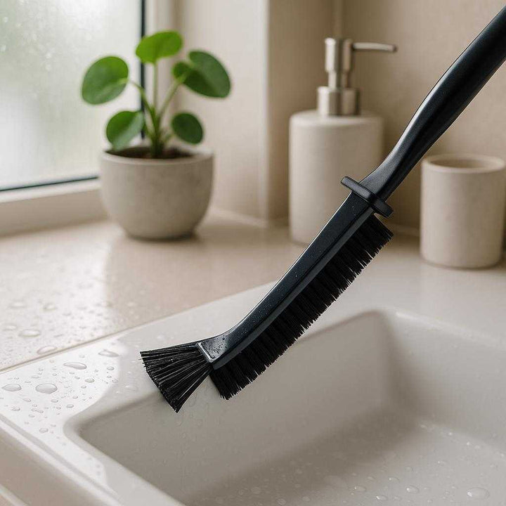 Sprækkebørste i sort og hvidt design - Effektiv til rengøring af smalle områder: A bathroom scenario, where the product is being used to clean the narrow spaces around a sleek, modern sink.