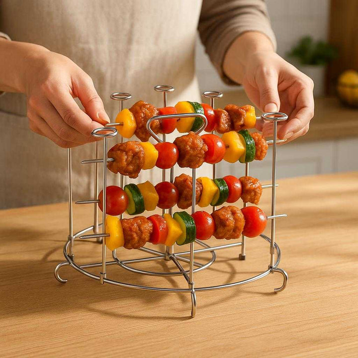 Spydstativ til Airfryer i Rustfrit Stål - Professionel Tilberedning med Høj Kvalitet og Holdbarhed: A realistic kitchen counter setting where the stainless steel air fryer rack is properly grounded on a wooden surface, being actively used by a person who is placing skewers of vegetables and meat on it, with natural lighting casting realistic shadows on the counter and showing clear contact points where the rack touches the surface.