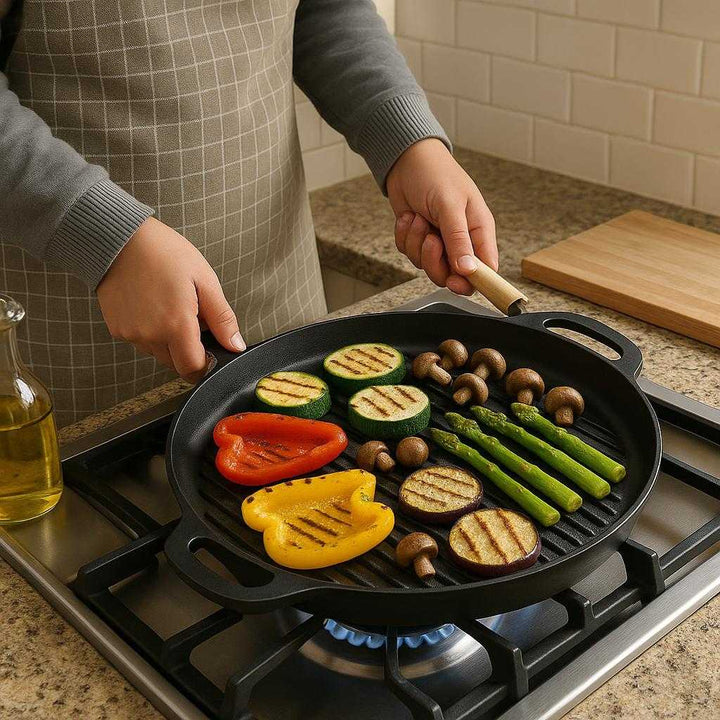 Støbejern Grillplade Sort - Jævn Varmefordeling, Holdbar, Ovnfast: A realistic kitchen setting where the Støbejern Grillplade Sort is properly grounded on a stovetop, being actively used by a person grilling a variety of vegetables.
