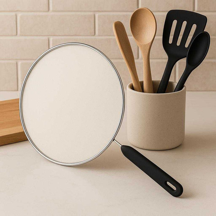 Stænkbeskytter i Rustfrit Stål – Professionel og Elegant Design til Effektiv Beskyttelse i Køkkenet. The elegant stainless steel splash guard resting on a kitchen counter next to a neatly arranged set of cooking tools, highlighting its sleek design.