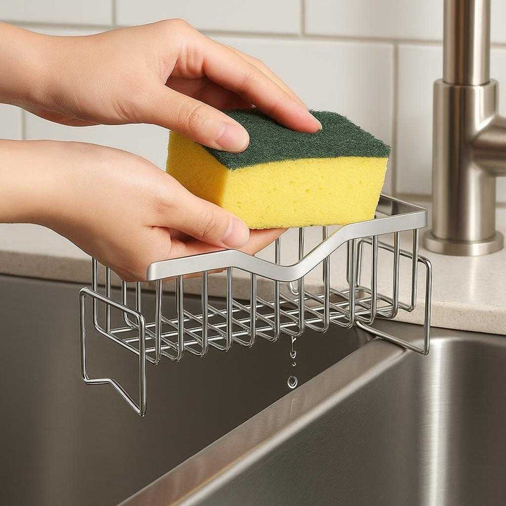 Svampeholder i Rustfrit Stål med Magnetisk Funktion og Effektiv Dræning til Køkkenvask: A realistic kitchen setting where the stainless steel sponge holder is properly grounded on the edge of a modern kitchen sink, being used by hands to easily place a wet sponge into the holder.