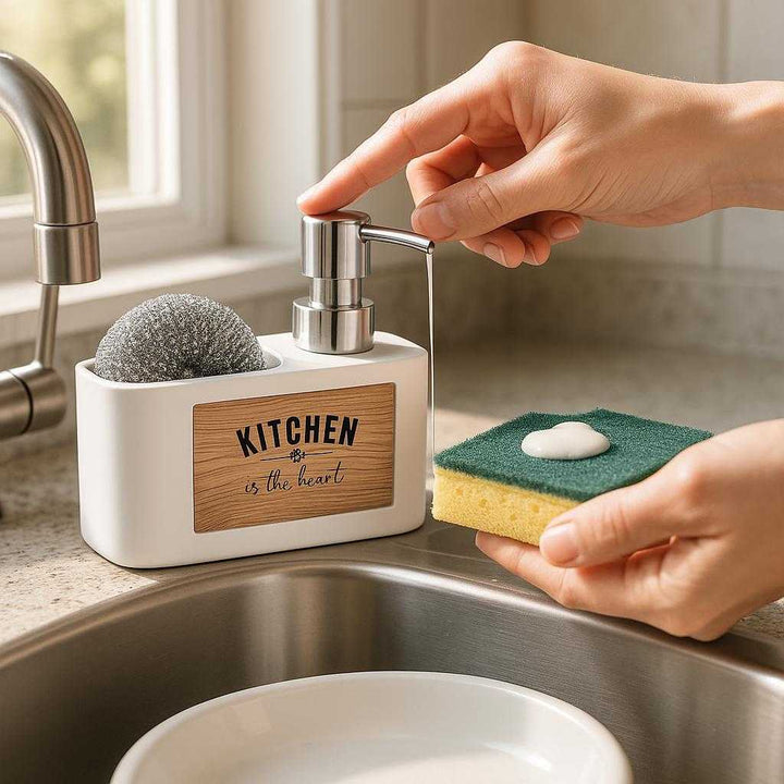 Svampeholder med Sæbepumpe til Vask i Hvid og Sort – Elegant Funktionalitet til Moderne Køkkener. The elegant white and black sponge holder with a soap pump is placed beside a modern kitchen sink, with a person reaching to pump soap onto a dish-filled sponge as sunlight streams through the window.