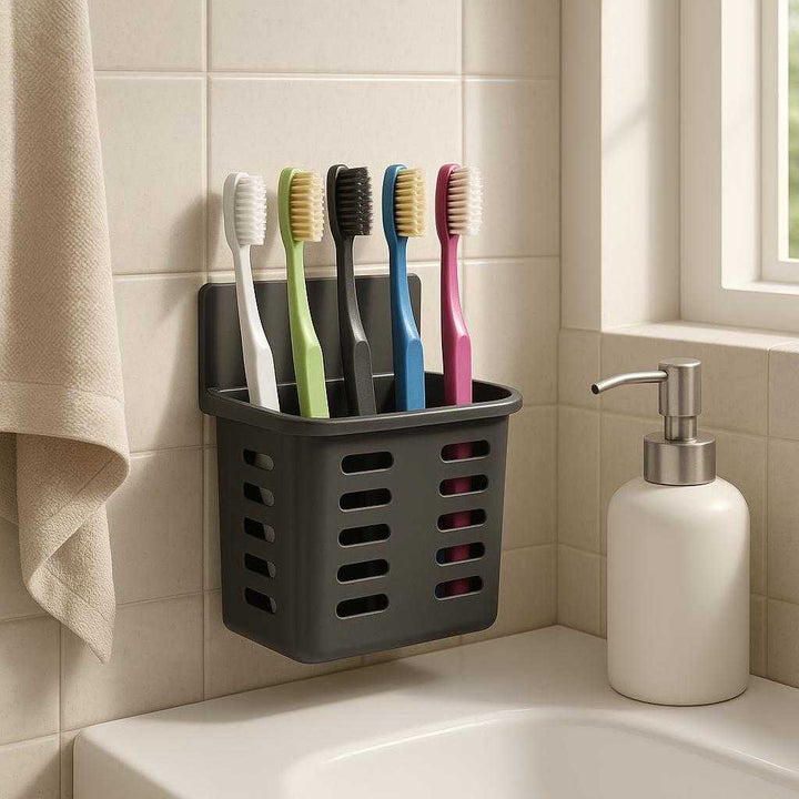 Tandbørsteholder til væg i moderne sort design - Plastik med mat finish, plads til 5 tandbørster: A realistic bathroom setting where the toothbrush holder is properly grounded on the tiled wall next to a sink, being naturally placed and securely holding five colorful toothbrushes.