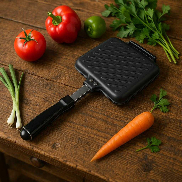 Toastjern til Komfur – Klassisk Sandwichjern i Sort Støbt Aluminium, Ergonomisk Design, Høj Kvalitet. The ergonomic sandwich iron is displayed on a rustic wooden kitchen counter, alongside vibrant vegetables and herbs, ready for a cozy meal preparation.
