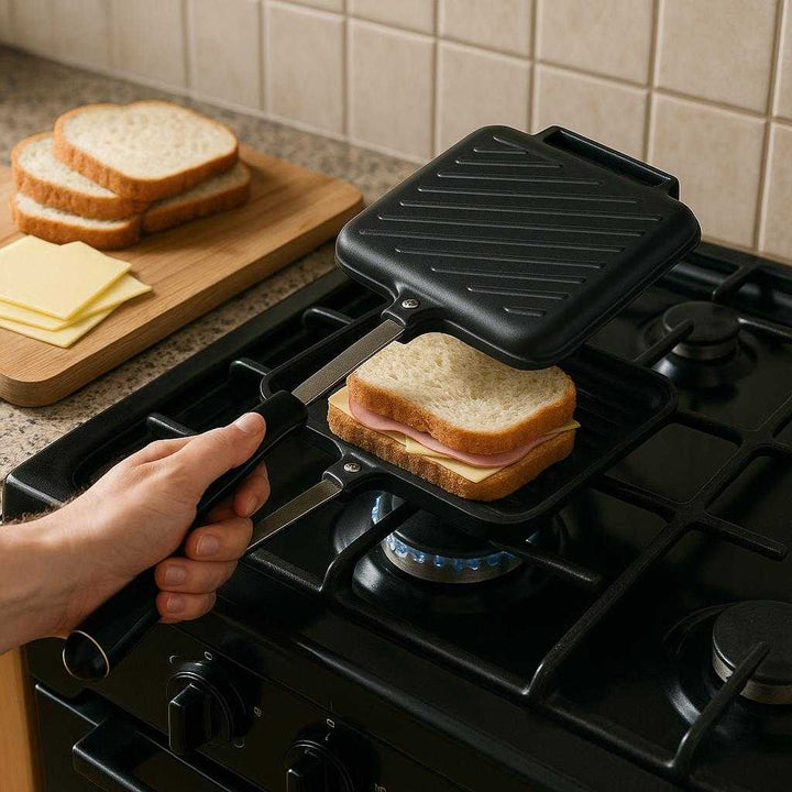 Toastjern til Komfur – Klassisk Sandwichjern i Sort Støbt Aluminium, Ergonomisk Design, Høj Kvalitet: A realistic kitchen setting where the Toastjern til Komfur is properly grounded on a stovetop, being actively used by a person to make a sandwich, with natural lighting casting realistic shadows.