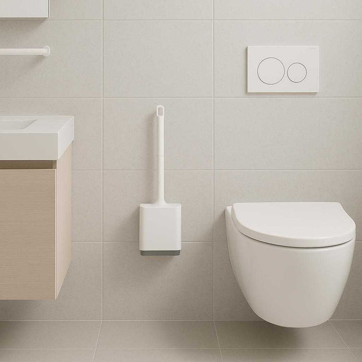 Toiletbørste i Moderne Design - Væghængt, Silikone, Tilgængelig i Hvid og Sort. A minimalist bathroom showcases the wall-mounted silicone toilet brush in white, perfectly complementing the contemporary decor with clean lines and neutral tones.