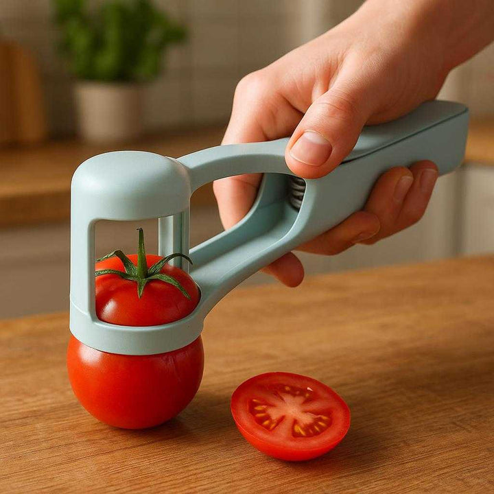Tomatskærer tilbehør – Præcisionspresser i moderne design: A realistic kitchen countertop setting where the product is properly grounded on a sturdy wooden table, being actively used by a person's hand to slice a ripe tomato.