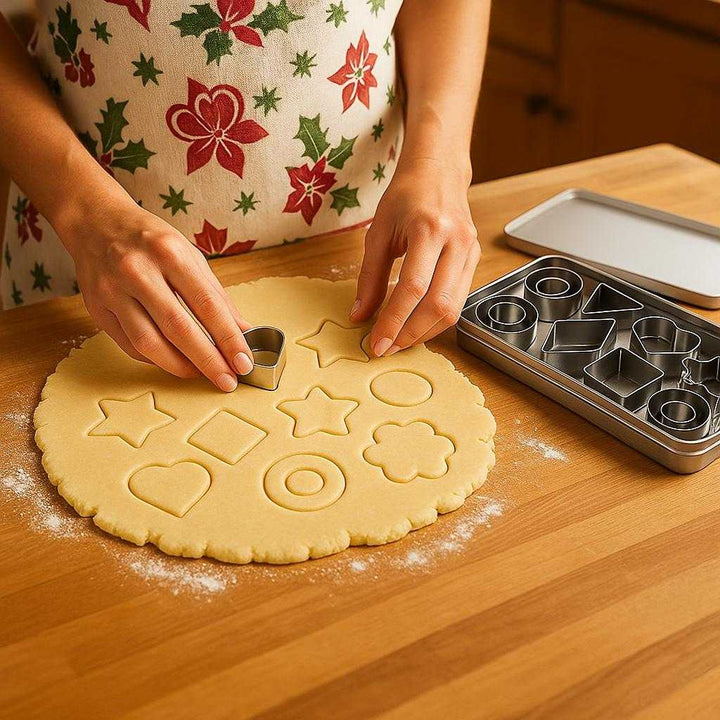 Udstiksforme i Rustfrit Stål – 12 Dele Professionel Sæt til Kreativ Bagning med Høj Kvalitet: A realistic kitchen setting where the product is properly grounded on a wooden countertop, being actively used by a person's hands to cut fun shapes out of rolled-out cookie dough.