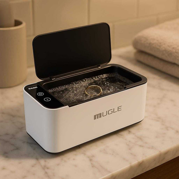 Ultralydsrenser – Kompakt Professionel Rens til Smykker, Briller og Ure, Høj Kvalitet og Avanceret Design: A different realistic bathroom setting where the product is securely positioned on a solid marble countertop, being used to clean a gold ring placed inside it.