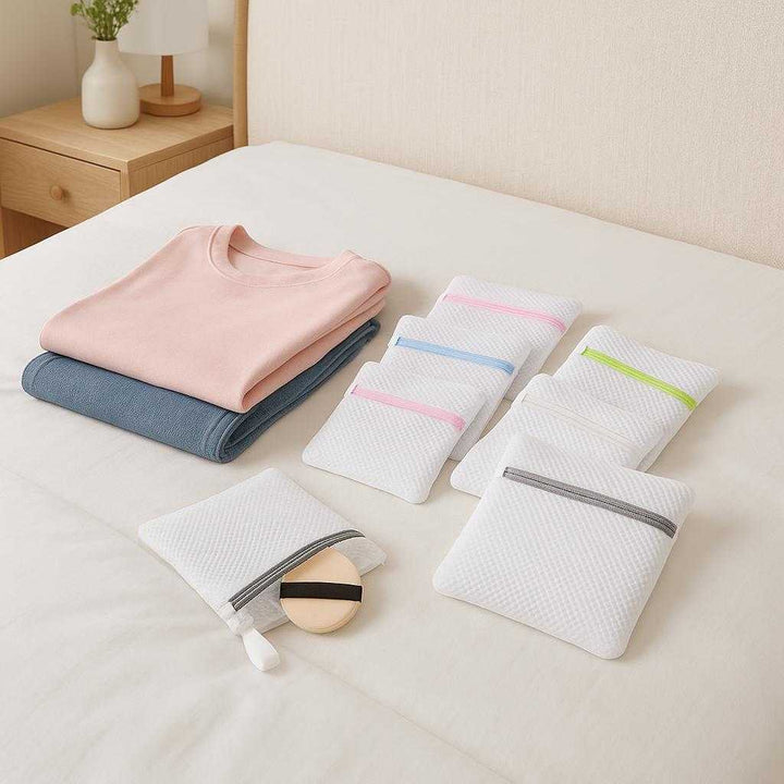 Vaskeposer i Mesh med Lynlås – Professionel Beskyttelse til Sko, Tøj og Undertøj i Flere Farver. A bedroom scene showcasing neatly folded clothes on a bed with mesh laundry bags in pastel colors laid out, suggesting organization and protection for travel packing.