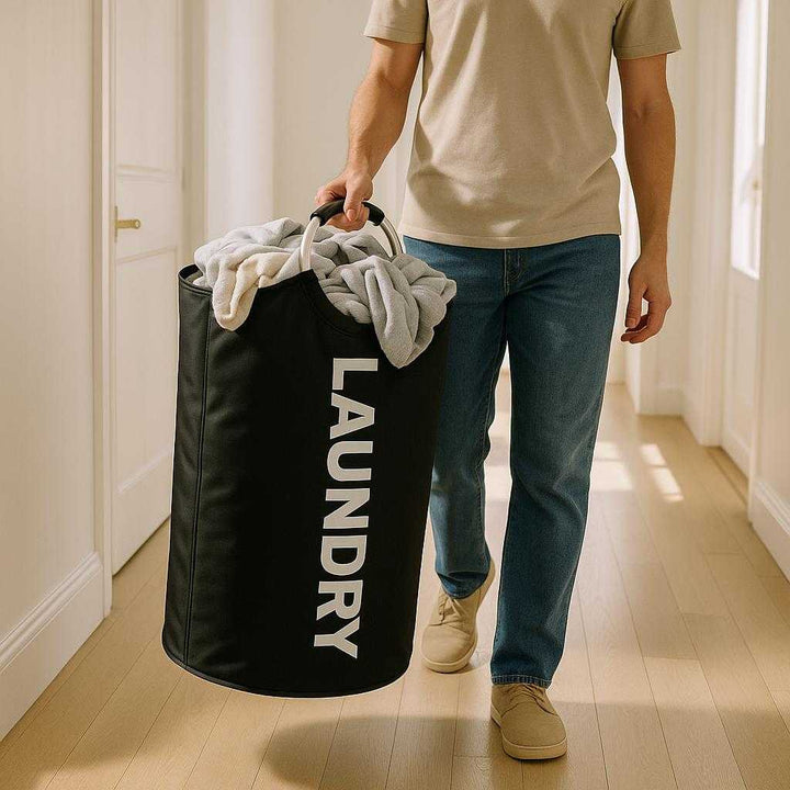 Vasketøjspose: Praktisk og letvægts til hjemmet og vaskerummet - Sort og hvid. The practical laundry bag is carried effortlessly down a bright hallway, filled with clothes, emphasizing its lightweight and convenient design.