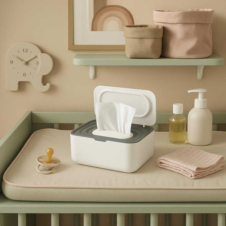Vådservietboks med Låg i Høj Kvalitet - Stilren og Funktionel Opbevaring til Moderne Hjem. In a stylish nursery room, the Vådservietboks med Låg sits on a changing table with pastel accents, surrounded by baby care items, creating a serene and functional atmosphere.